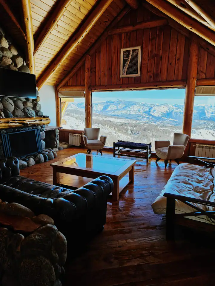 Interior acogedor de la cabaña con sala de estar y chimenea